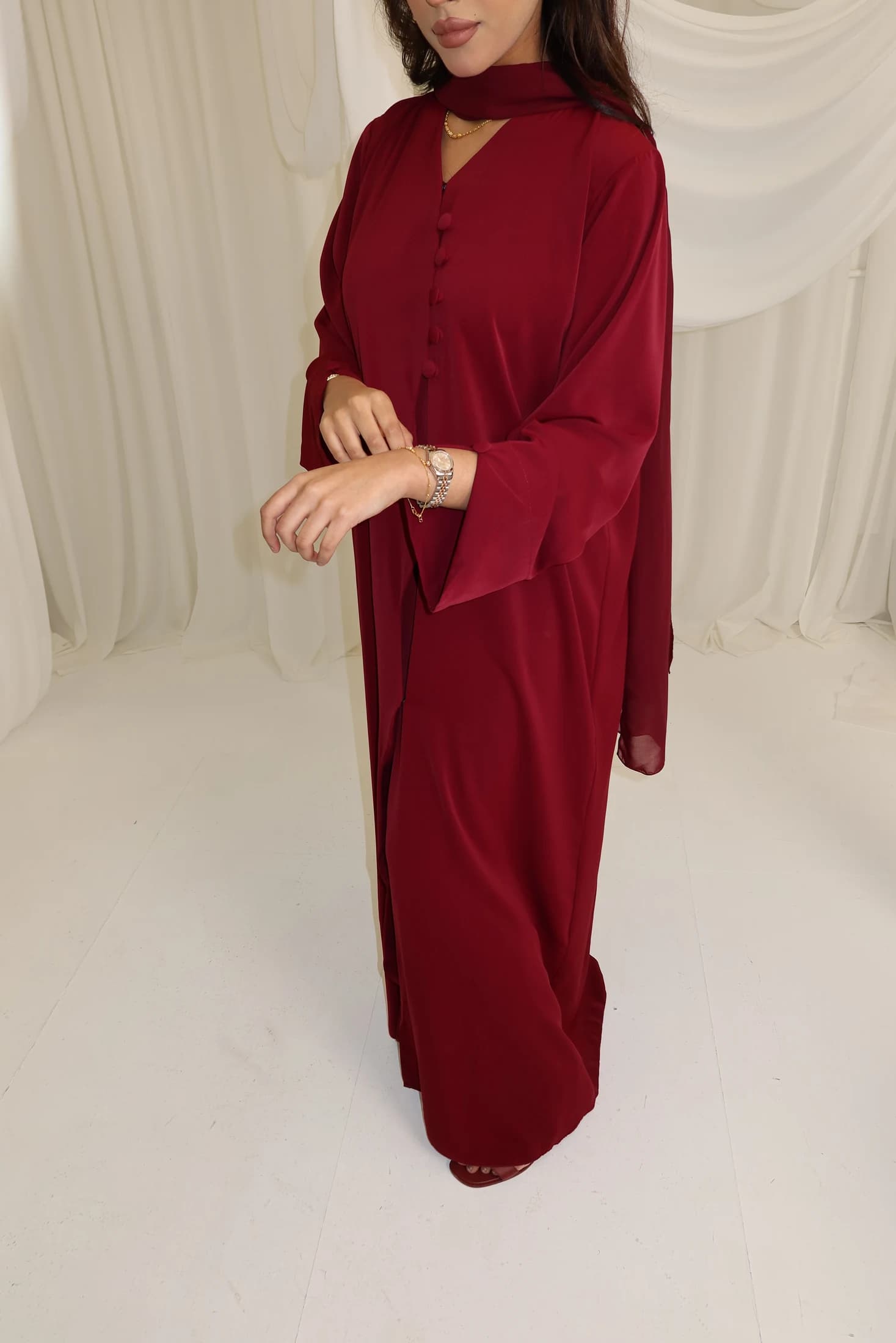 Front view of a burgundy abaya with a matching scarf.